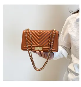 Détail du sac bandoulière marron matelassé en V avec fermoir doré et chaîne