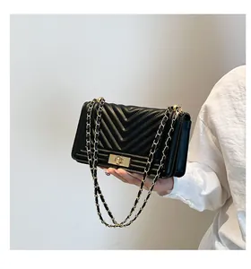 Détail du sac bandoulière noir en cuir matelassé avec chaîne dorée et fermoir pivotant