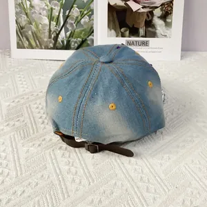 Detail of vintage denim baseball cap with leather adjustable strap and metal buckle