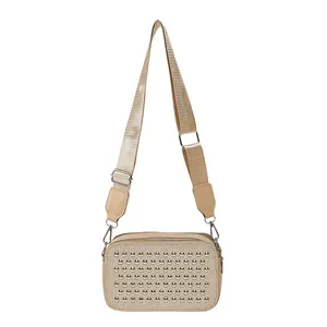 Beige woven crossbody camera bag with silver rivets and wide adjustable strap