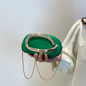 Borsa chic in pelle verde smeraldo con manico ad anello dorato e tracolla in catena