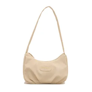 Borsa hobo minimalista in tela beige con dettagli pieghettati e chiusura a zip