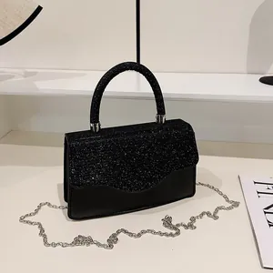 Sac de soirée noir scintillant avec rabat à bord ondulé et bandoulière en chaîne