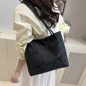 Elegant black jacquard tote bag with butterfly embroidery and stylish fringe detail