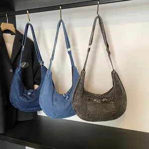 Three colors of denim hobo crossbody bags in navy blue, light blue, and washed black