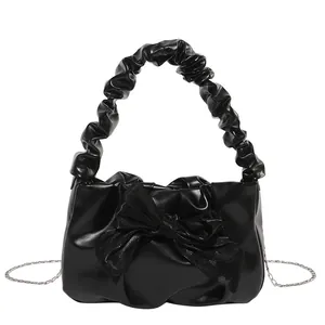 Chic black pleated handbag with oversized bow detail and silver chain strap for women