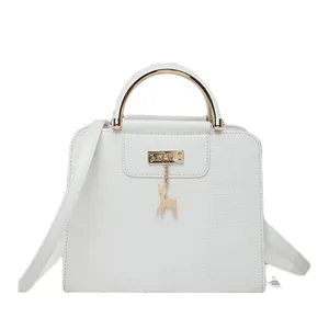 White faux-crocodile crossbody bag with gold handle and delicate deer charm