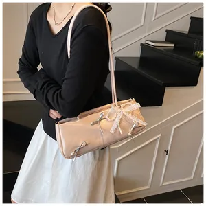 Detail of pink PU leather shoulder bag with silver bows and pearl lace charm