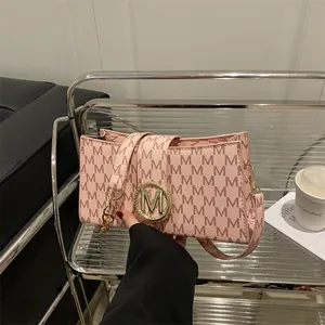 Pink crossbody bag with red M monogram pattern and golden sparkling logo buckle