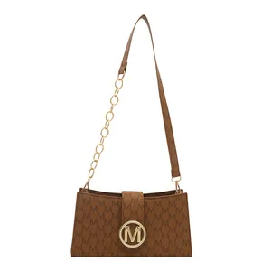 Brown fashion flap bag with M-letter monogram print and gold metal buckle detail
