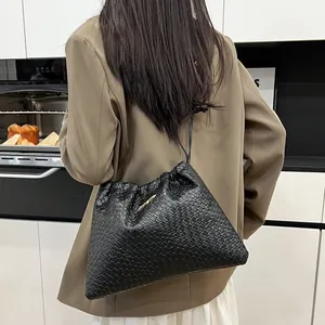 Sac seau noir tressé avec cordon de serrage et logo métallique doré chic