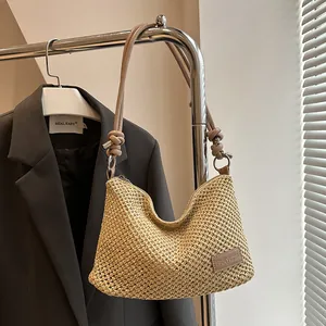 Sac bandoulière chic en paille tissée avec lanières en cuir et anneau en métal sur cintre