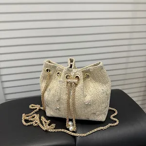 Beige straw bucket bag with floral embroidery, chain strap and pearl drawstring charms
