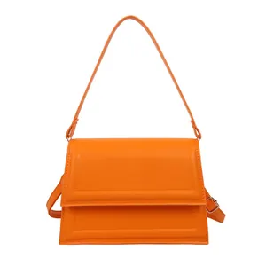 Elegant bright orange crossbody handbag with rectangular flap and gold buckle hardware