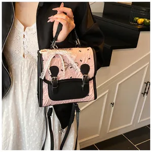 Nahaufnahme des rosa gefalteten Rucksacks mit Spitzenanhänger und Perlendetails