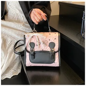 Nahaufnahme des rosa Rucksacks mit schwarzen Schleifen, Spitze und Perlenkette