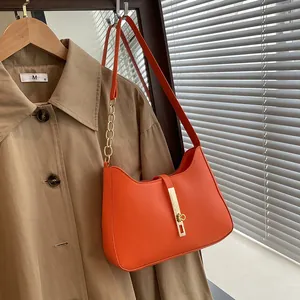 Oranje lederen hobo schoudertas met gouden ketting en metalen gesp voor dames