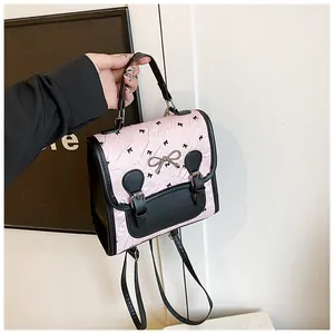 Detail des rosa gefalteten Rucksacks mit schwarzem Schleifenmuster und Metallbogen