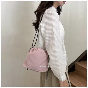 Fashion nylon drawstring bucket bag in pink color shown on model side-view