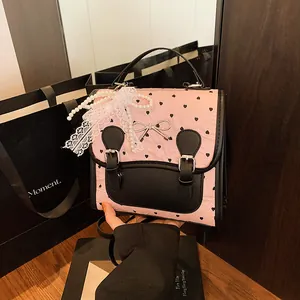 Rosa Rucksack mit Herzprägung, schwarzem Besatz, Metallschleife und Perlenspitzanhänger