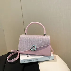 Pink fashion handbag with glitter flap and silver heart buckle on decorative books