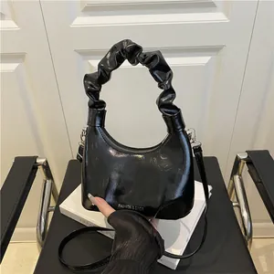 Elegant black glossy leather half-moon bag with scrunchie handle and silver fashion text