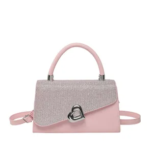 Pink crossbody square bag with sequin flap and heart buckle in a 45-degree view