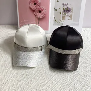 Detail of satin baseball caps with sequined brims and rhinestone belt buckle accents