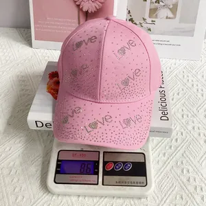 Vue détaillée de la casquette rose avec lettrage Love en strass brillants sur une balance