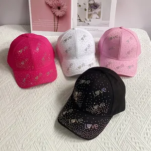 Détail de casquettes de baseball colorées avec lettres LOVE en strass et motifs cœur