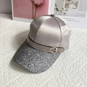 Detail of silver satin baseball cap with rhinestone strap and glitter brim design