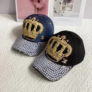 Detail of crown embroidery and purple pearls on blue denim and black baseball caps