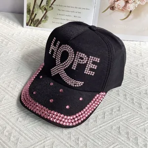 Close-up of pink rhinestones forming the HOPE text on a black cotton baseball cap