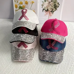 Detail of denim baseball caps with pink rhinestone ribbon motifs and crystal brims