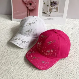 Détail de casquettes de baseball blanches et roses avec lettrage LOVE en strass brillants