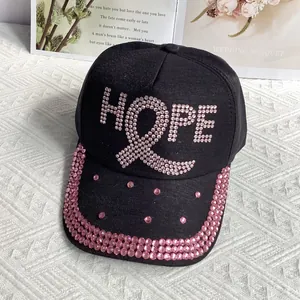 Close-up of pink rhinestones forming HOPE text and ribbon on a black baseball cap