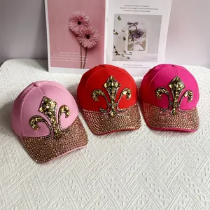 Detailed view of colorful denim baseball caps with rhinestones and fleur-de-lis pattern