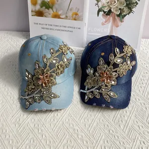 Detail der Blumenstickerei und funkelnden Strasssteine auf Denim-Baseballkappen