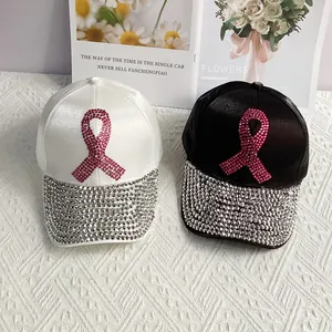 Close-up of denim baseball caps with pink rhinestone ribbons and sparkling brim details