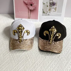 Denim baseball caps featuring golden rhinestone fleur-de-lis patterns in black and white