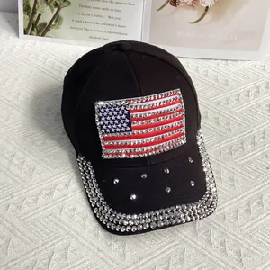 Close-up detail of rhinestone encrusted American flag patch on a black cotton baseball cap