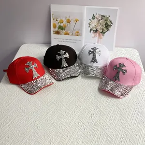Top view of baseball caps in red, black, white, and pink with rhinestone cross details