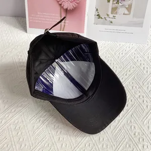Detailed interior of black denim baseball cap with metal buckle and shape holder