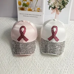 Pink and white baseball caps with rhinestone ribbons and crystal-covered brims