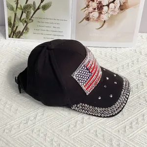 Detail shot of a black cotton baseball cap featuring a rhinestone American flag and sparkling brim