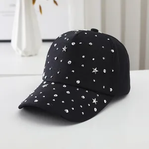 Detail einer schwarzen Baumwollkappe mit glitzernden Strasssteinen und Sternennieten