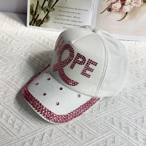 Close-up of white baseball cap with pink rhinestones forming the HOPE text design