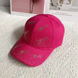Détail de la casquette rose rouge avec strass argentés formant le mot LOVE et coeur