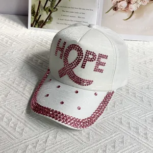 Detail of pink rhinestone HOPE lettering and ribbon on a white fashion baseball cap