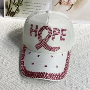 Detailed close-up of white baseball cap with pink rhinestones HOPE and ribbon motif